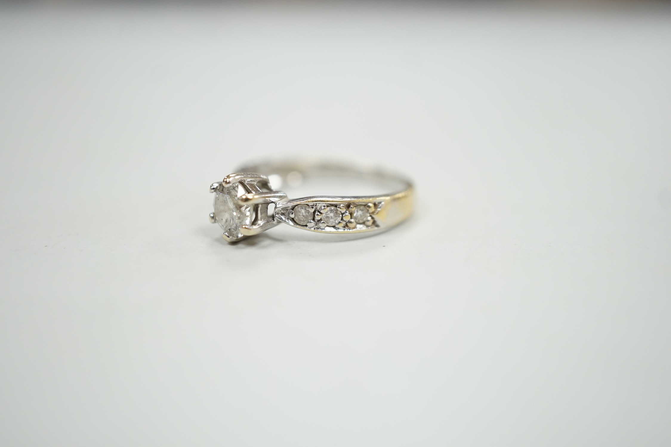 A modern 18ct gold and single stone diamond ring, with diamond set shoulders, size J, gross weight 2.4 grams